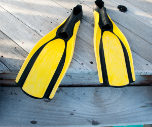 Yellow scuba diving fins on a jetty