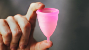Hand holding and presenting a menstrual cup